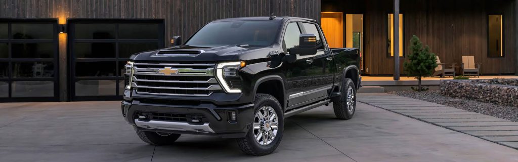 2026 Chevy Silverado luxury pickup truck parked outside a contemporary home, showcasing upscale styling, comfort-focused features, and versatile capability.